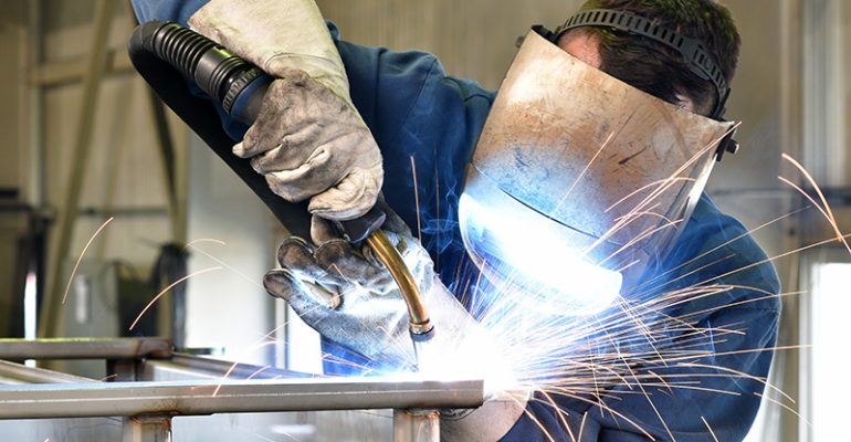 welder works in metal construction - construction and processing of steel components